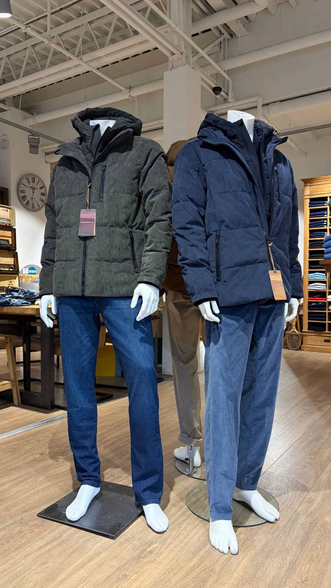 Twee paspoppen in gewatteerde winterjassen van Finnmark, een groene en een blauwe, met een jeans en een ribcord broek.